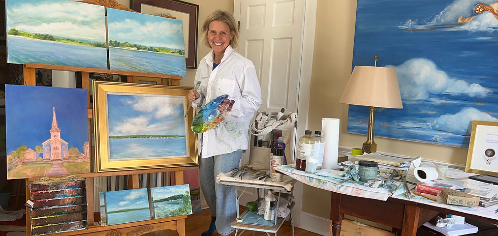 Jennifer Hooley smiling in her colorful Cazenovia art studio